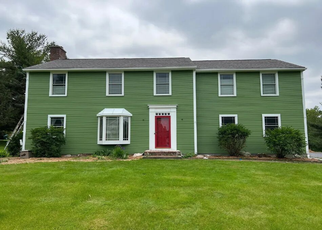 A-two-story-residential-home-with-a-green-exterior-paint-job